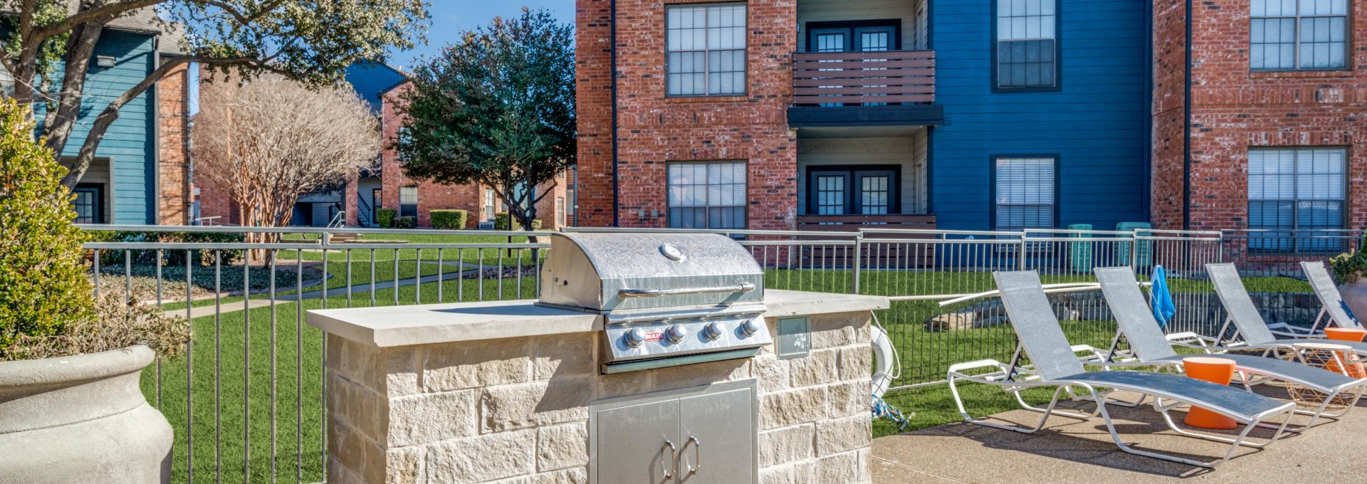 a grill and chairs in front of an apartment building at The  Dayton